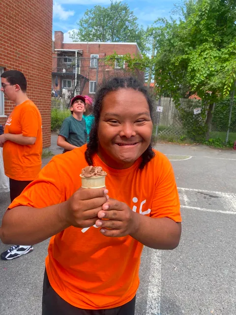 Jeune souriant avec une crème glacée dans la cour d'école.