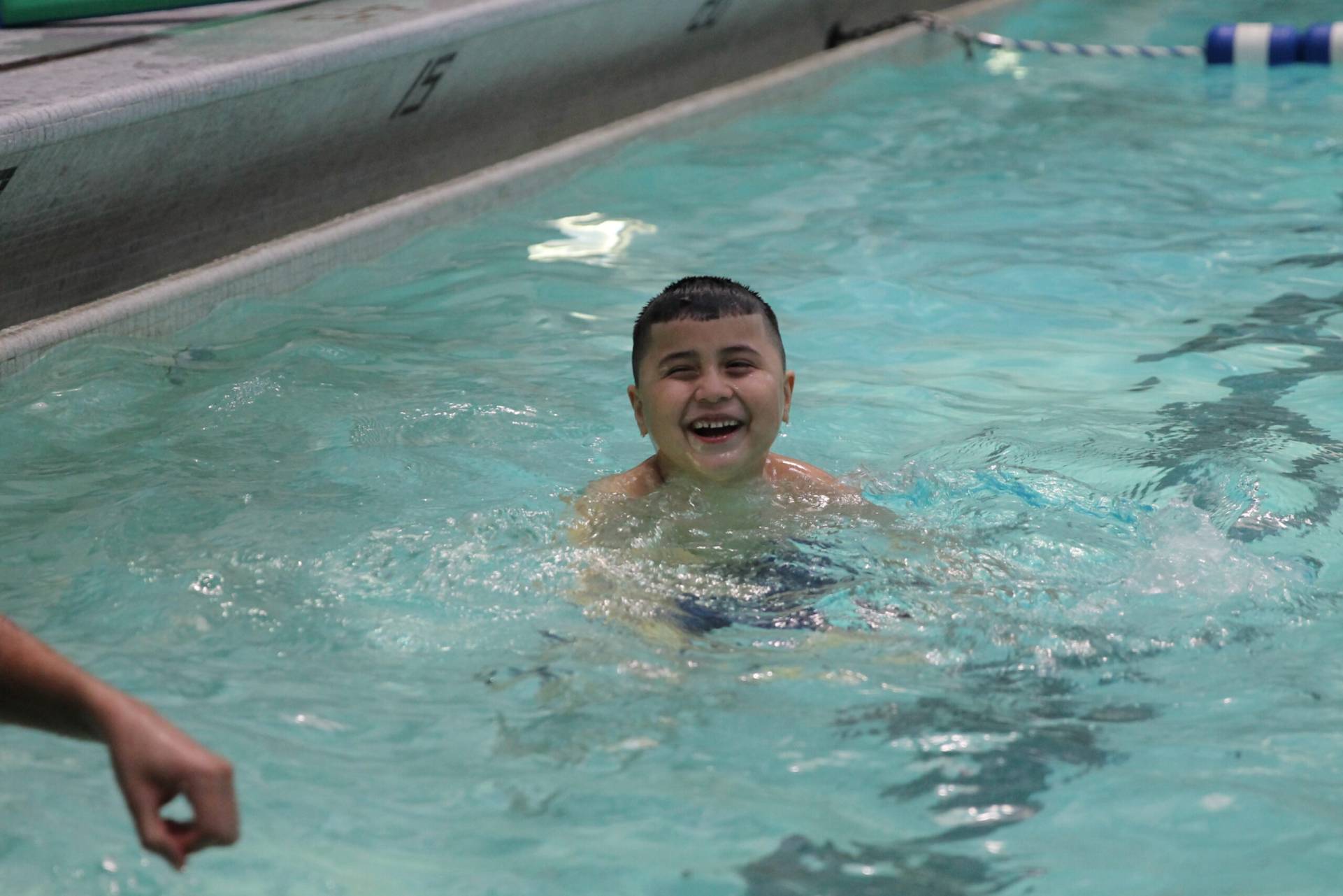 Jeune enfant souriant dans la piscine